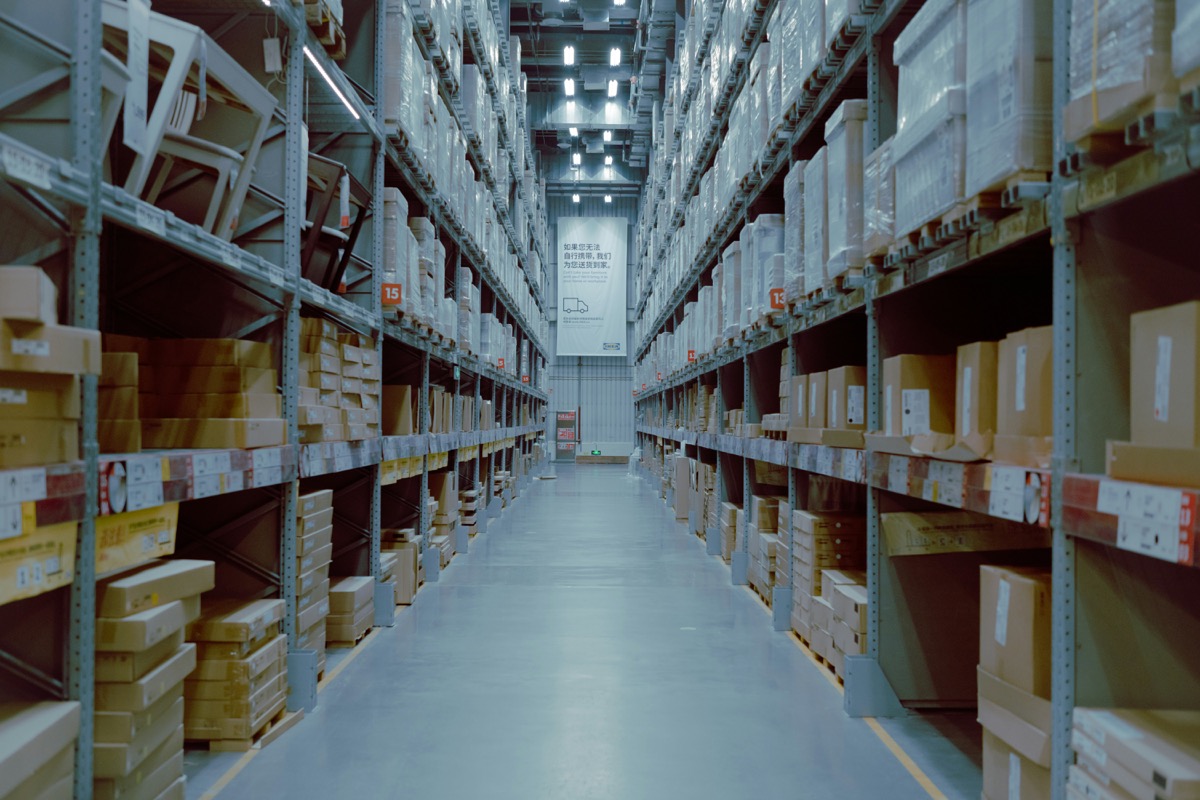 Warehouse shelves stacked with inventory. Photo by Lance Chang on Unsplash.